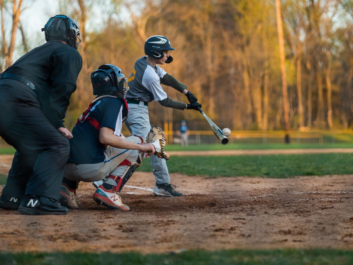 A baseball glove, ball and bat lying on the grass — Bat & Bucket, youth baseball & softball gear